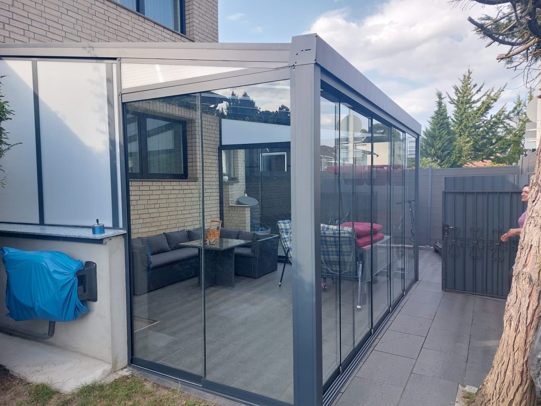 Le salon vitré vu de côté, avec son triangle latéral opale et le portillon du jardin